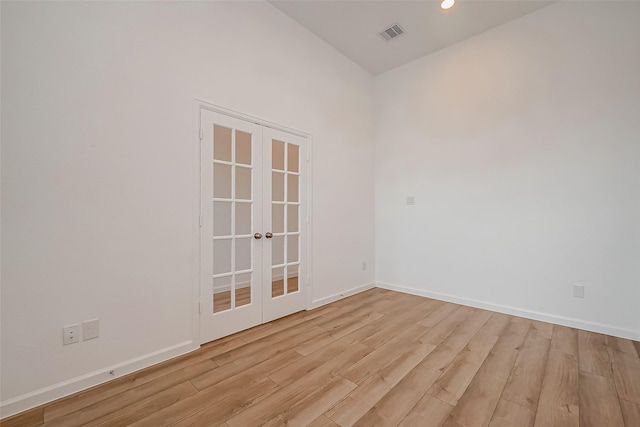 empty room with french doors, baseboards, light wood-type flooring, and visible vents