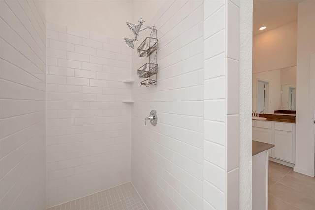 full bathroom featuring a tile shower, tile patterned floors, vanity, and recessed lighting