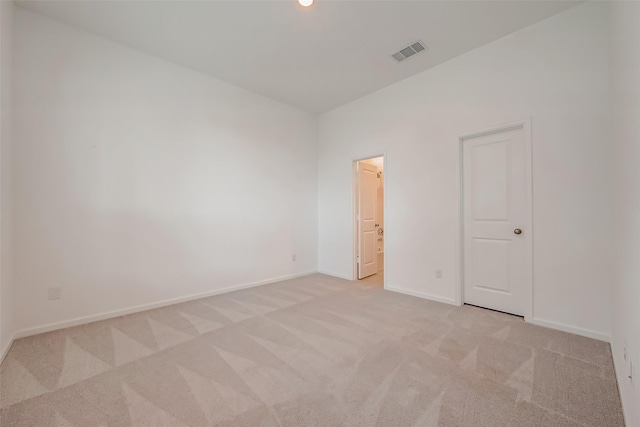 empty room featuring light carpet, baseboards, and visible vents