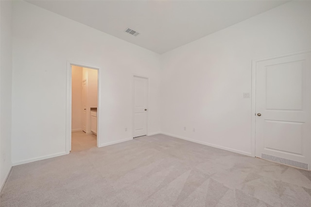 empty room with light carpet, baseboards, and visible vents
