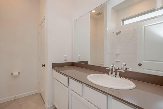 bathroom featuring baseboards, toilet, a shower, vanity, and tile patterned flooring