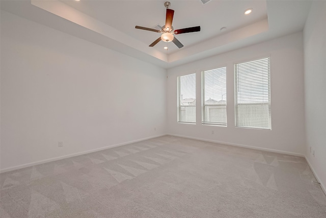 unfurnished room with baseboards, recessed lighting, a ceiling fan, a tray ceiling, and light colored carpet