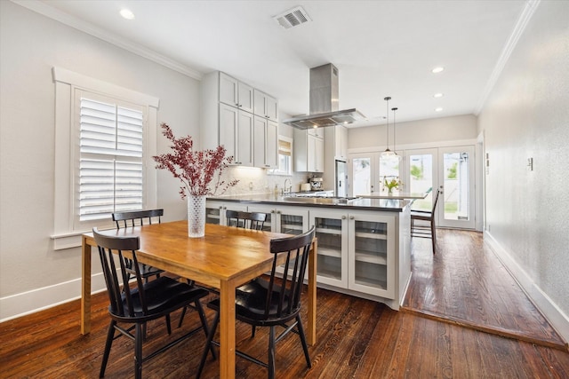 dining room featuring visible vents, baseboards, ornamental molding, and dark wood finished floors