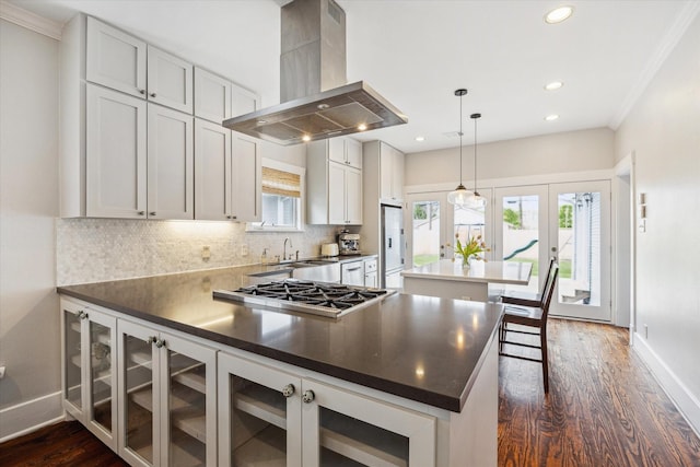 kitchen with tasteful backsplash, stainless steel gas stovetop, baseboards, and exhaust hood