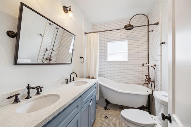 bathroom featuring toilet, double vanity, and a sink