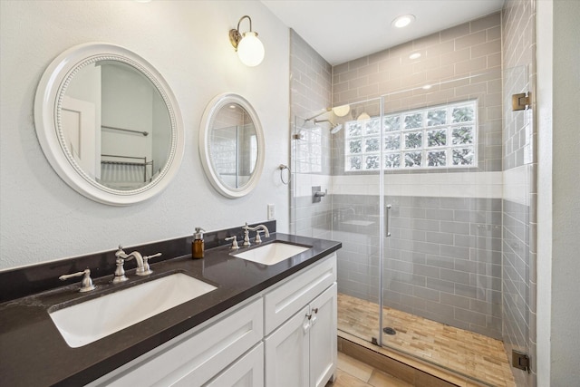 bathroom with a sink, recessed lighting, and a stall shower