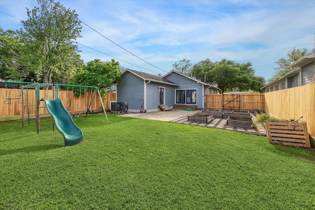 back of house featuring a yard, a fenced backyard, a garden, a playground, and central AC unit