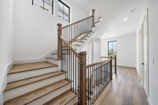 staircase featuring hardwood / wood-style floors, baseboards, and recessed lighting