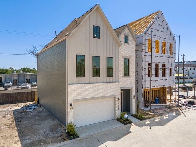 view of front facade featuring brick siding, board and batten siding, and an attached garage