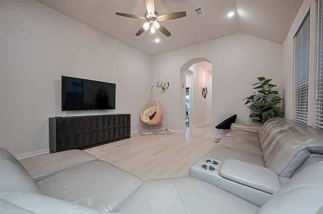 living room featuring ceiling fan, arched walkways, visible vents, wood finished floors, and lofted ceiling