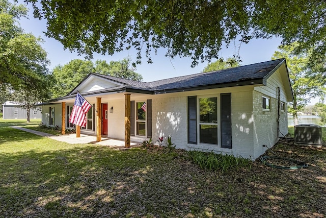 652 E Taylor Lake Cir, Livingston, TX 77351 - view of front facade featuring brick siding, a front yard, a patio, and cooling unit
