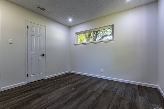 652 E Taylor Lake Cir, Livingston, TX 77351 - spare room featuring dark wood-style flooring, baseboards, a textured ceiling, and visible vents