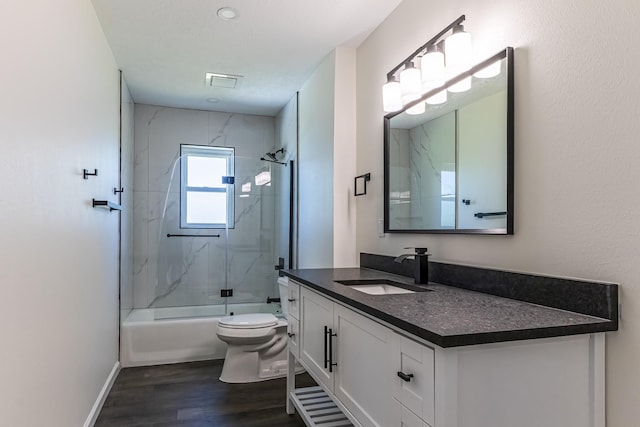 652 E Taylor Lake Cir, Livingston, TX 77351 - bathroom featuring vanity, toilet, visible vents, bath / shower combo with glass door, and wood finished floors