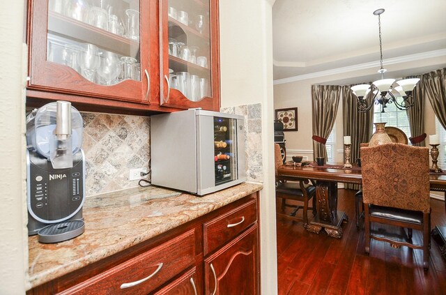 25419 Richton Falls Dr, Richmond, TX 77406 - kitchen with dark wood finished floors, an inviting chandelier, reddish brown cabinets, white microwave, and glass insert cabinets