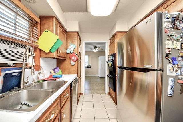 13230 Ferry Hill Ln, Houston, TX 77015 - kitchen with appliances with stainless steel finishes, a sink, brown cabinets, and light tile patterned floors
