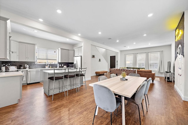 dining area featuring baseboards, recessed lighting, and light wood finished floors