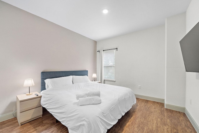 bedroom with wood finished floors and baseboards