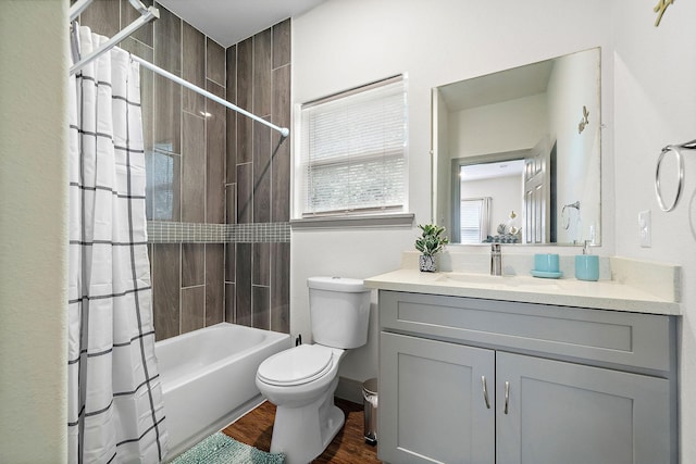 full bath featuring shower / bath combo, wood finished floors, toilet, and vanity