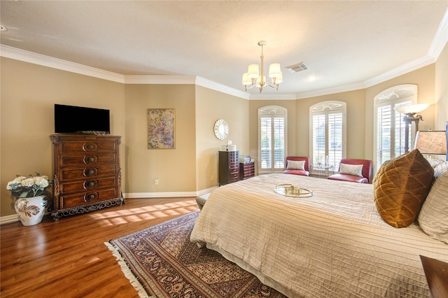 bedroom with a chandelier, visible vents, baseboards, ornamental molding, and wood finished floors