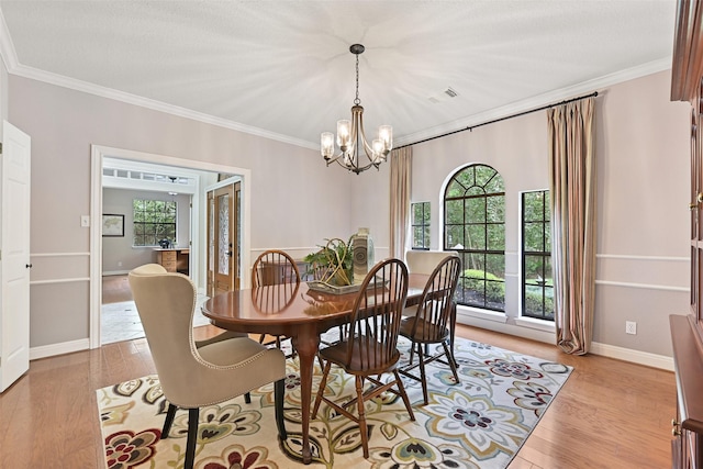 dining room featuring light wood finished floors, an inviting chandelier, ornamental molding, and plenty of natural light