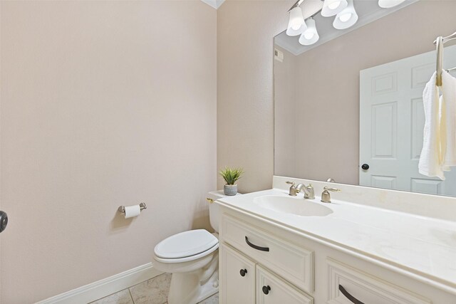 bathroom featuring toilet, vanity, baseboards, and tile patterned flooring