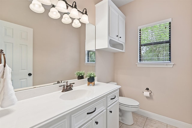 bathroom featuring tile patterned flooring, vanity, baseboards, and toilet