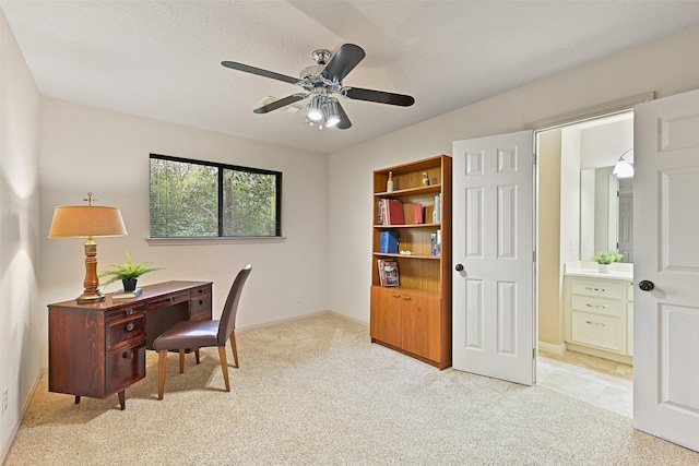 office space with light colored carpet and a ceiling fan