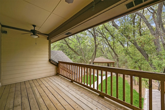 wooden deck featuring ceiling fan, visible vents, and a lawn