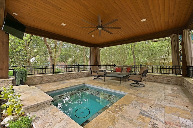 view of pool with ceiling fan, outdoor lounge area, a patio, fence, and a jacuzzi