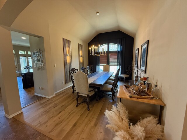 29046 Davenport Dr, Katy, TX 77494 - dining area featuring wood finished floors, lofted ceiling, baseboards, arched walkways, and a notable chandelier