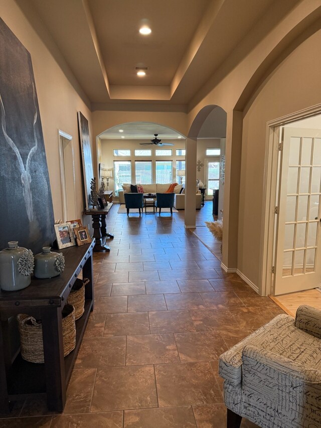 29046 Davenport Dr, Katy, TX 77494 - hall with a raised ceiling, arched walkways, recessed lighting, baseboards, and stone finish flooring
