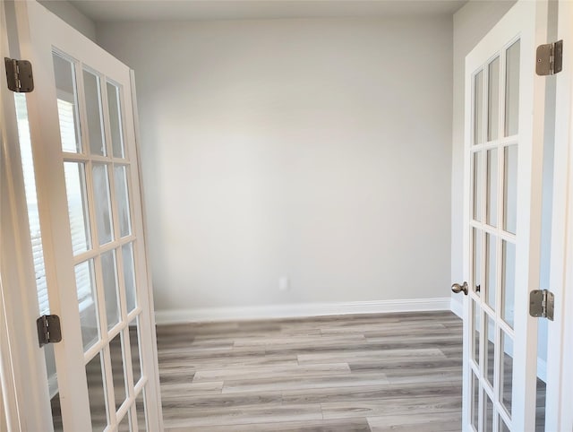 unfurnished room with french doors, wood finished floors, and baseboards