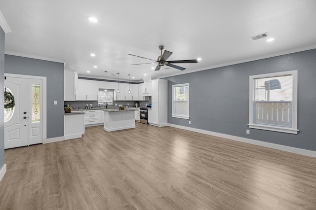 unfurnished living room with visible vents, baseboards, crown molding, and ceiling fan
