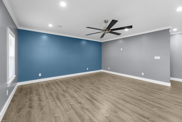 spare room featuring crown molding, wood finished floors, ceiling fan, and baseboards