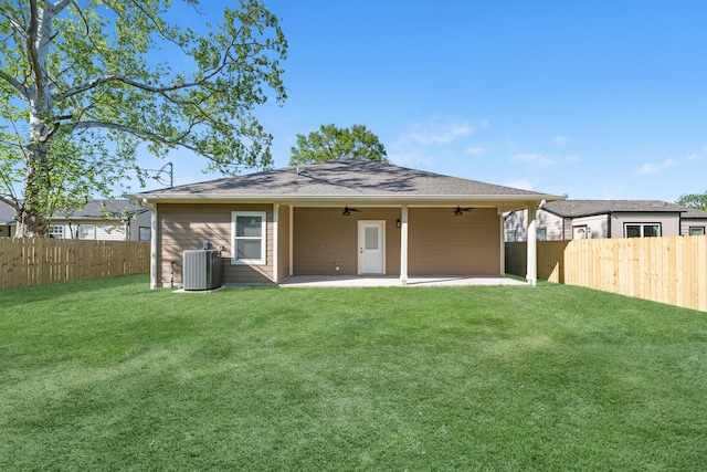 back of house with a ceiling fan, a patio area, central AC, a fenced backyard, and a lawn
