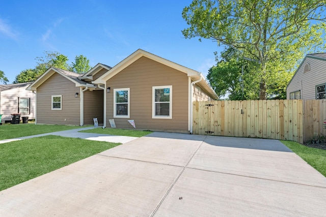 single story home featuring a front yard, fence, and a gate
