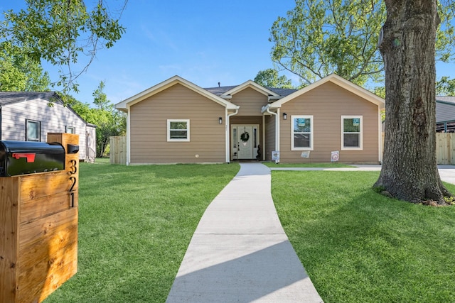 ranch-style home featuring a front yard and fence