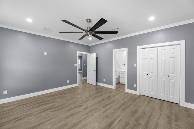 unfurnished bedroom with visible vents, crown molding, connected bathroom, and wood finished floors