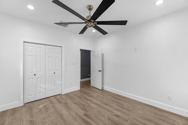 unfurnished bedroom featuring a closet, recessed lighting, baseboards, and wood finished floors