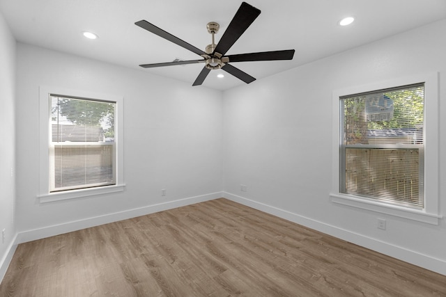 empty room featuring a wealth of natural light, recessed lighting, and wood finished floors