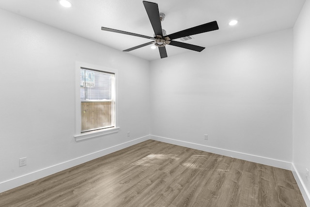 spare room featuring wood finished floors, baseboards, a ceiling fan, and recessed lighting
