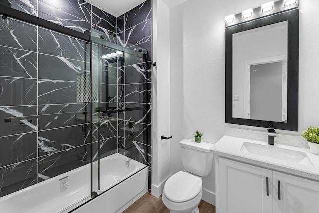bathroom with toilet, shower / bath combination with glass door, wood finished floors, and vanity