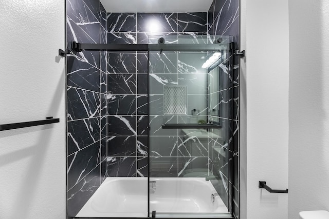 full bath featuring a textured wall and enclosed tub / shower combo