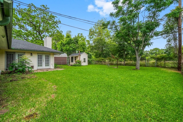 1702 Sheridan Dr, Baytown, TX 77520 - view of yard featuring french doors, an outdoor structure, and a storage shed