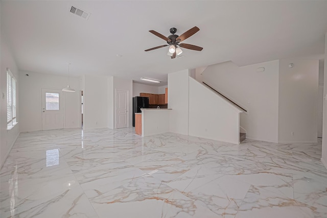 7727 N Friesian Meadow Ln NW, Humble, TX 77338 - unfurnished living room with ceiling fan, stairway, and light marble finish floors