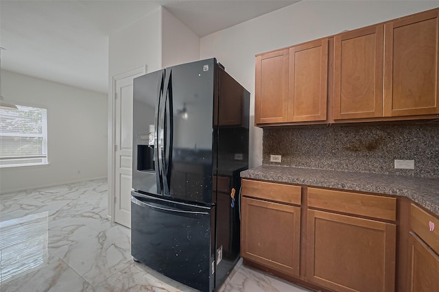 7727 N Friesian Meadow Ln NW, Humble, TX 77338 - kitchen with black fridge with ice dispenser, light marble finish floors, brown cabinets, and backsplash