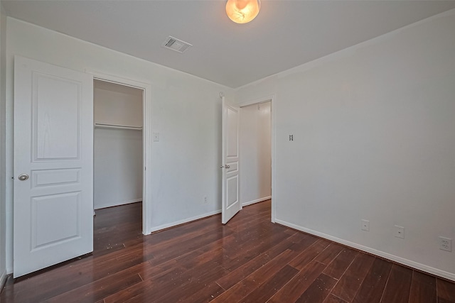 7727 N Friesian Meadow Ln NW, Humble, TX 77338 - unfurnished bedroom featuring dark wood-style floors, a closet, and a spacious closet