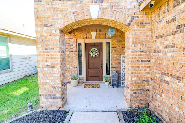 view of exterior entry with brick siding