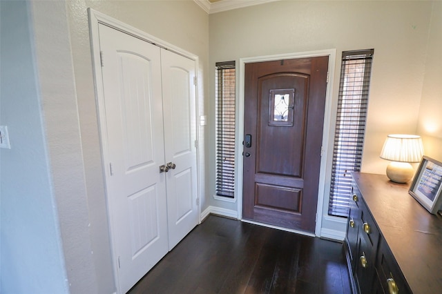 foyer with baseboards, ornamental molding, and dark wood finished floors