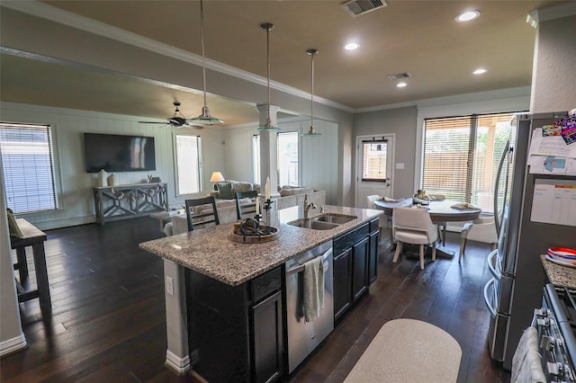 kitchen featuring stainless steel appliances, a sink, a center island with sink, dark wood-style flooring, and crown molding